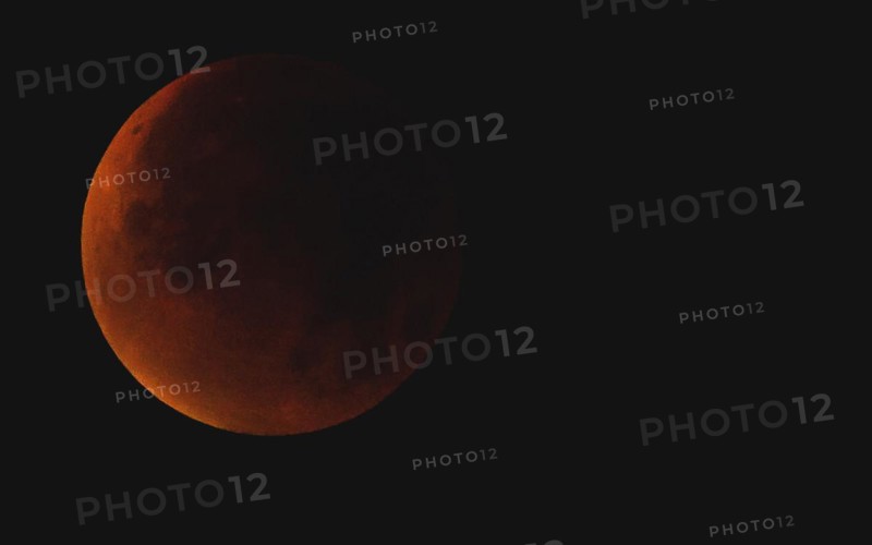 A reddish moon during a total lunar eclipse in the dark night sky, Haan, North Rhine-Westphalia, Germany, Europe