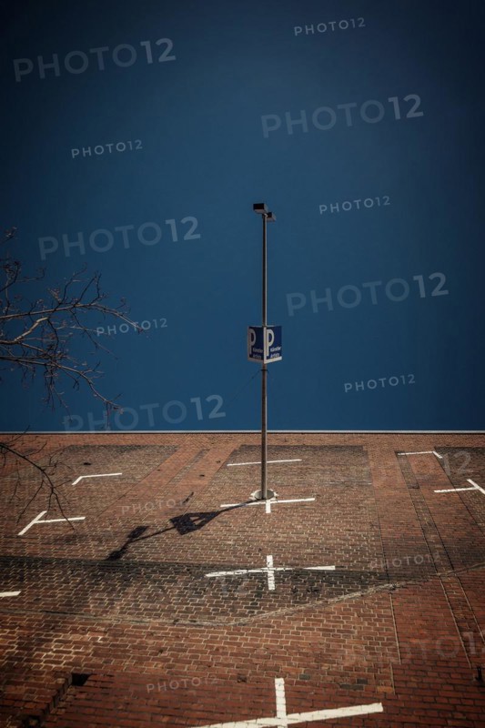 Lighting column and car park sign cast a shadow on a large brick wall, Cologne Deutz, North Rhine-Westphalia, Germany, Europe