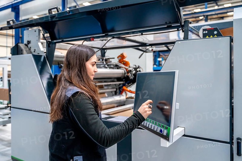 Female concentrated worker using cnc machine to control an industrial crane
