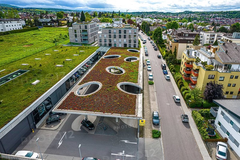 View from above of a building with a green roof, neighbouring meadow and street with cars, Edeka Weiherberg, Pforzheim, Germany, Europe