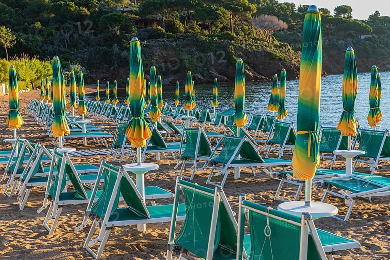 Sun loungers and parasols on Straccolignino beach at sunrise, near Capoliveri, Elba, Tuscan Archipelago, Tuscany, Italy, Europe