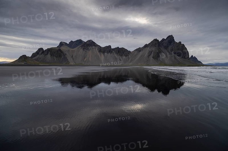 Vestrahorn, mountains with black lava sand, reflection in the water, south coast of Iceland