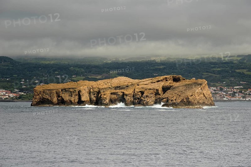 The remote rocky island 'Iieu Deitado' off a coastline of Pico under a cloudy sky, Iieu Deitado, Iieu em Pe, Horta, Faial, Azores, Portugal, Europe