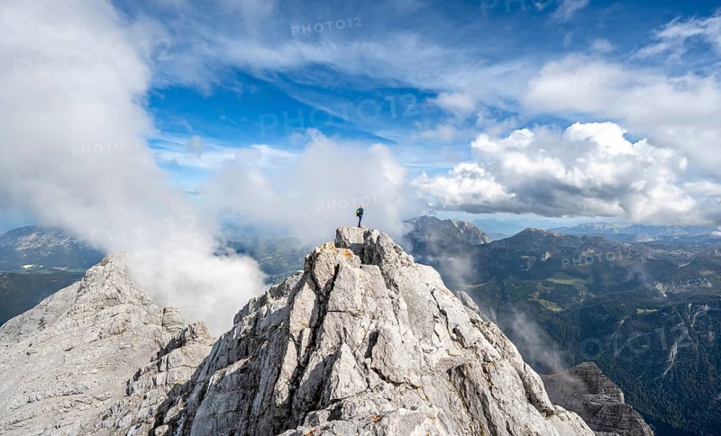 Mountaineer on the rocky summit of the Watzmann Mittelspitze, Watzmann crossing, view of mountain panorama, Berchtesgaden National Park, Berchtesgaden Alps, Bavaria, Germany, Europe
