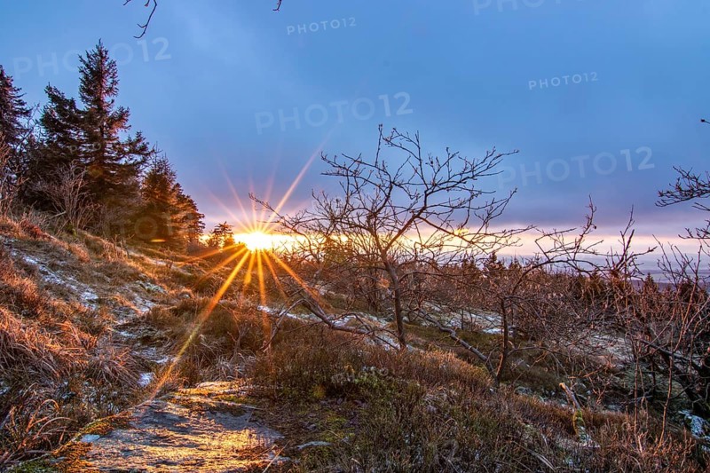 Landscape on the Grosser Feldberg, Taunus volcanic region. A cloudy, sunny winter day, meadows, hills, snow and forests with a view of the winter sunset. Hesse, Germany, Europe