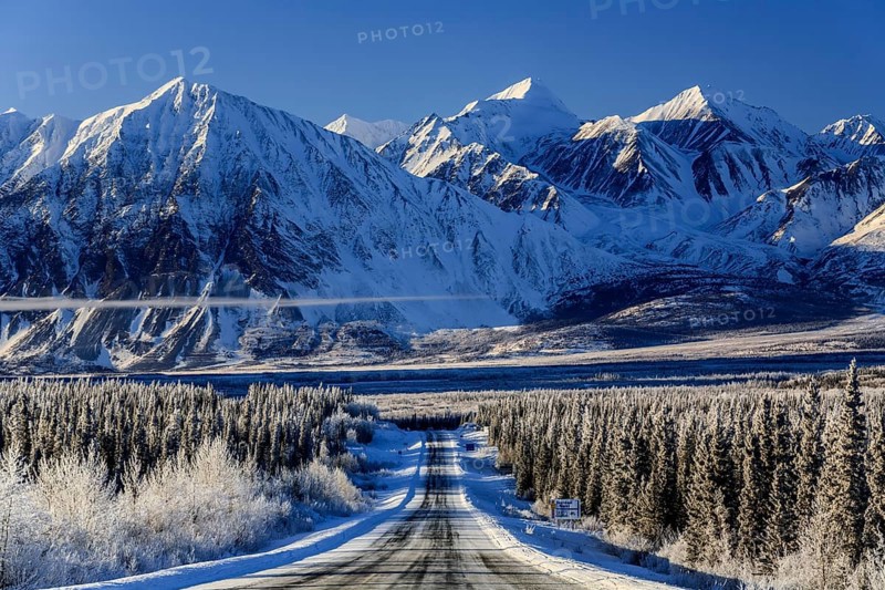 Highway in winter landscape in front of snow-covered mountains, Alaska Highway, Haines Junction, Yukon Territory, Canada, North America