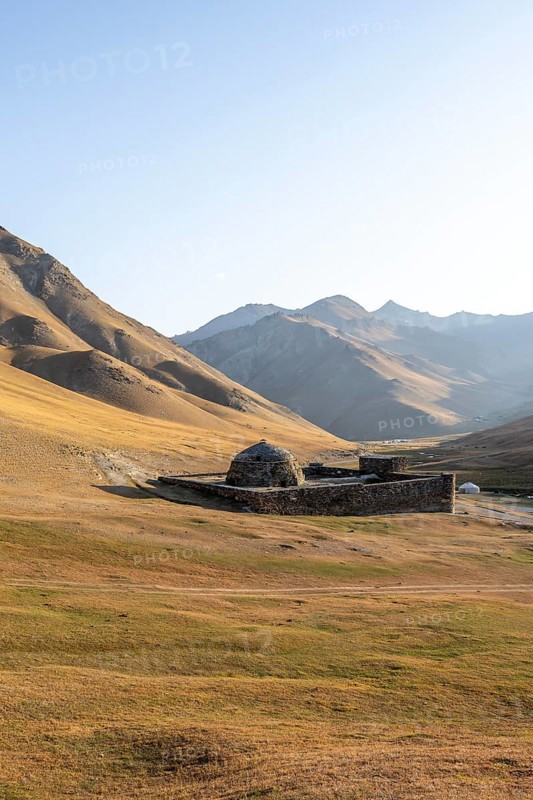 Historic caravanserai Tash Rabat from the 15th century, in the evening light with golden hills, Naryn region, Kyrgyzstan, Asia