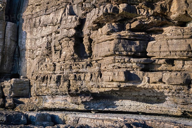 Beautiful texture of cliffs and rock formations in Peniche, Portugal, on sunny day. Weathered rock formations, geological interest, coastline, clear blue sky, background, texture, Europe