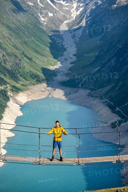 Mountaineers on a suspension bridge, picturesque mountain landscape near the Olpererhuette, view of turquoise-blue lake Schlegeisspeicher, Berliner Hoehenweg, Zillertal Alps, Tyrol, Austria, Europe