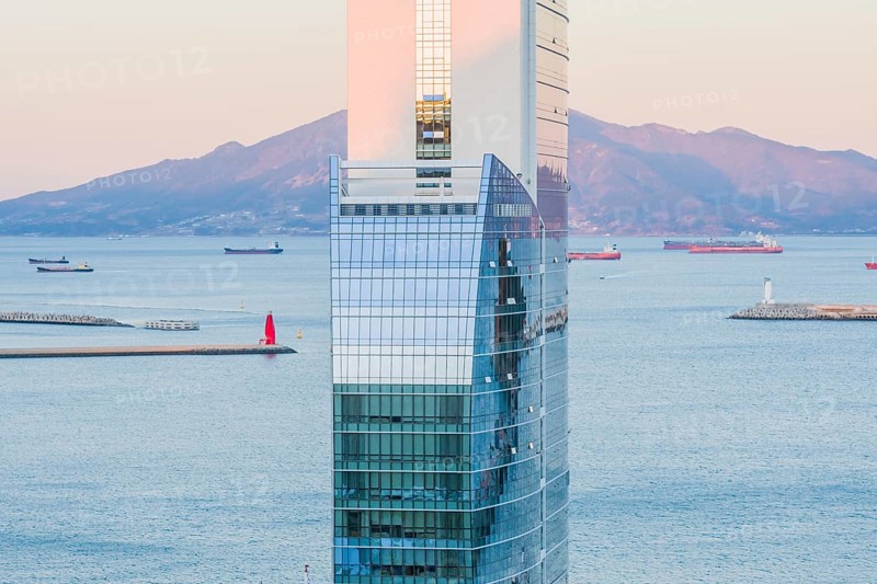 Yeoso, South Korea: December 25, 2017: Top of the MVL hotel with mountains and the harbor full of barges in the background