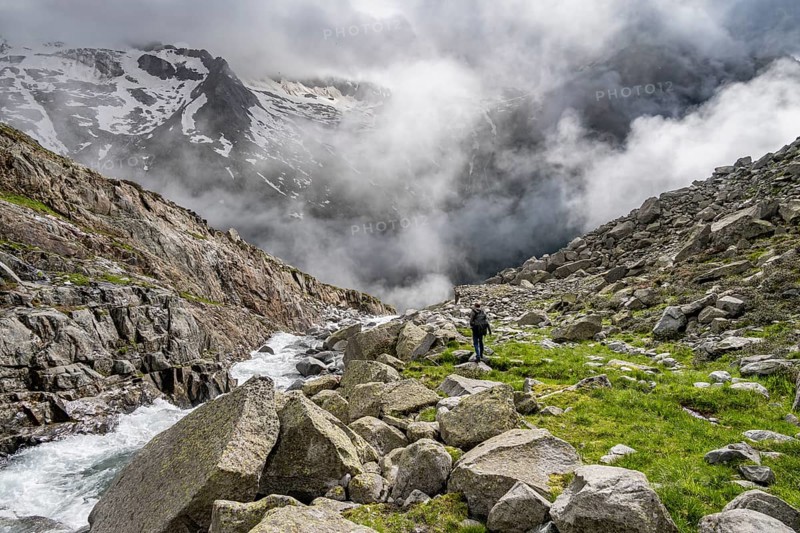 Mountaineer at a mountain stream, Furtschaglbach, cloudy mountains in the background, Furtschaglhaus, Berliner Hoehenweg, Zillertal, Tyrol, Austria, Europe