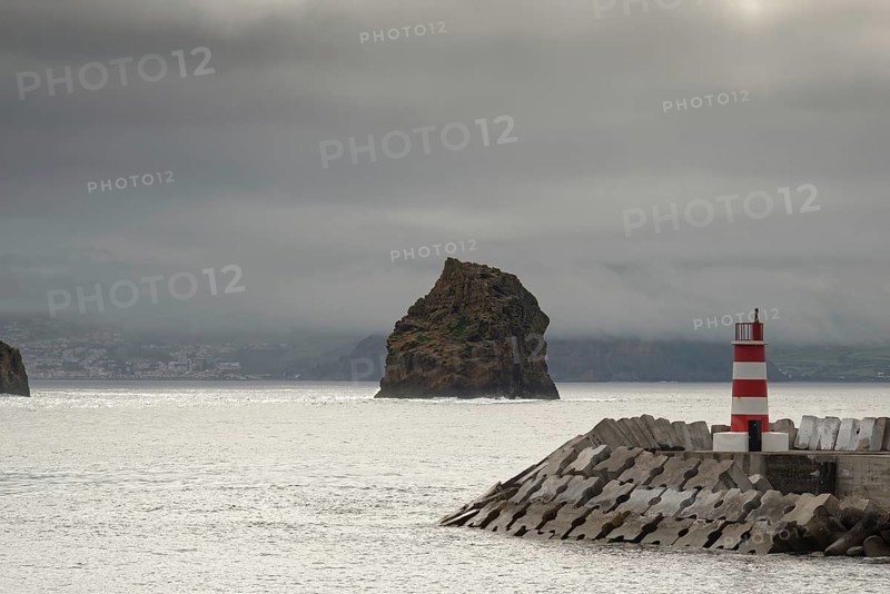 Breakwater and lighthouse by the sea with a rocky island 'Iieu em Pe' in the background on a foggy day, Iieu Deitado, Iieu em Pe, Horta, Faial, Azores, Portugal, Europe