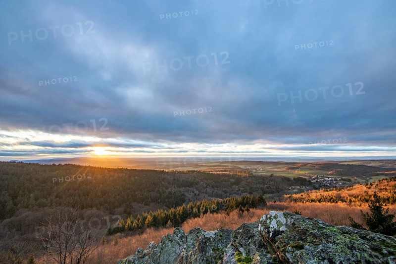 Landscape at the Grosser Zacken, Taunus volcanic region. A cloudy, sunny autumn day, meadows, hills, fields and forests with a view of the sunset. Hesse, Germany, Europe