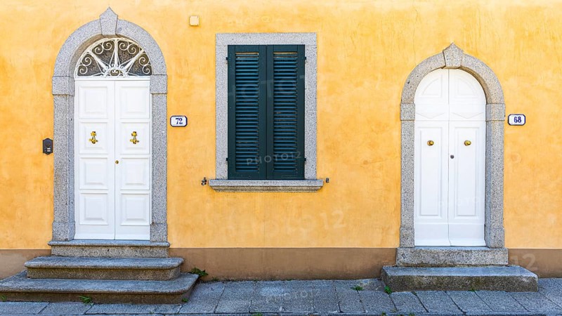 White arched front doors in pastel-coloured house wall, Sant'ilario in Campo, Elba, Tuscan Archipelago, Tuscany, Italy, Europe