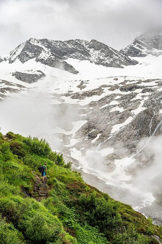 Mountaineers on a hiking trail, in the background glaciated peak Dosso Largo and glacier Schlegeiskees, cloudy atmospheric mountain landscape, ascent to Furtschaglhaus, Berliner Hoehenweg, Zillertal, Tyrol, Austria, Europe