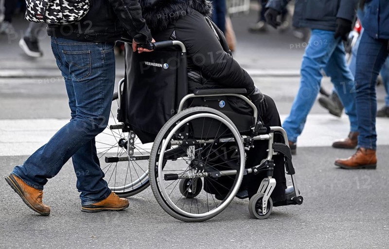 Symbol photo Man pushing wheelchair