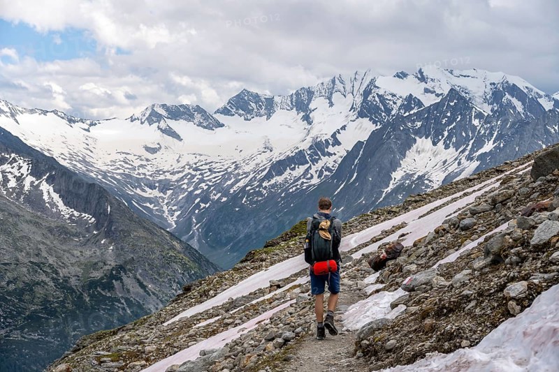 Mountaineer on hiking trail, Berliner Hoehenweg, mountain landscape with glaciated peaks Hochfeiler and Hoher Weisszint, Zillertal Alps, Tyrol, Austria, Europe
