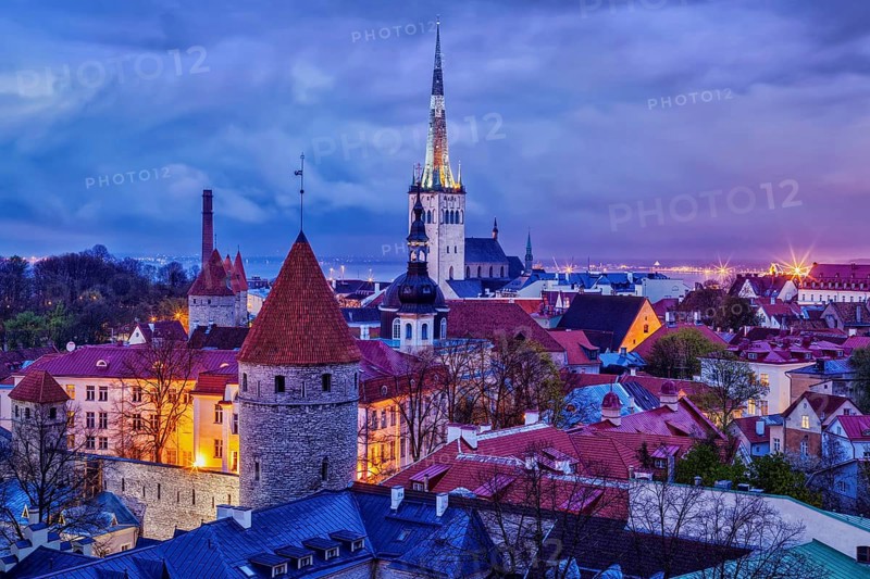 Aerial view of Tallinn Medieval Old Town with St. Olaf's Church and Tallinn City Wall illuminated in evening, Estonia, Europe