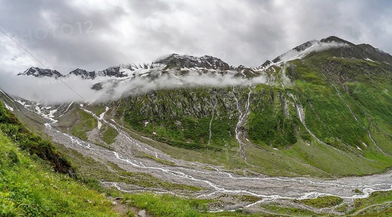 Cloudy valley of Schlegeisgrund with mountain stream, glaciated mountain peaks Hoher Weiszint and Hochsteller, Berliner Hoehenweg, Zillertal, Tyrol, Austria, Europe