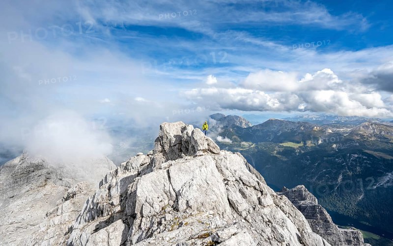 Mountaineer on the rocky summit of the Watzmann Mittelspitze, Watzmann crossing, view of mountain panorama, Berchtesgaden National Park, Berchtesgaden Alps, Bavaria, Germany, Europe