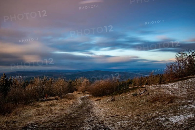 Landscape on the Grosser Feldberg, Taunus volcanic region. A cloudy, sunny winter day, meadows, hills, snow and forests with a view of the winter sunset. Hesse, Germany, Europe