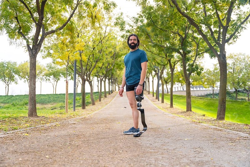 Portrait with wide view and copy space of a runner with a artificial leg standing outdoors