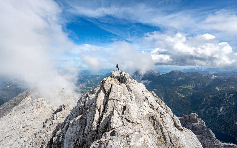 Mountaineer on the rocky summit of the Watzmann Mittelspitze, Watzmann crossing, view of mountain panorama, Berchtesgaden National Park, Berchtesgaden Alps, Bavaria, Germany, Europe