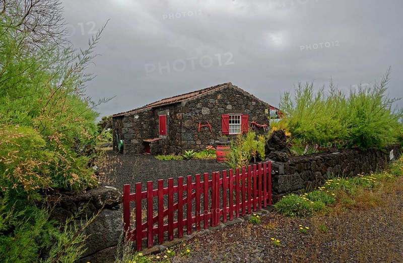 Stone house with red shutters and door and a red fence in a rural area, North Coast, Santa Luzia, Pico, Azores, Portugal, Europe