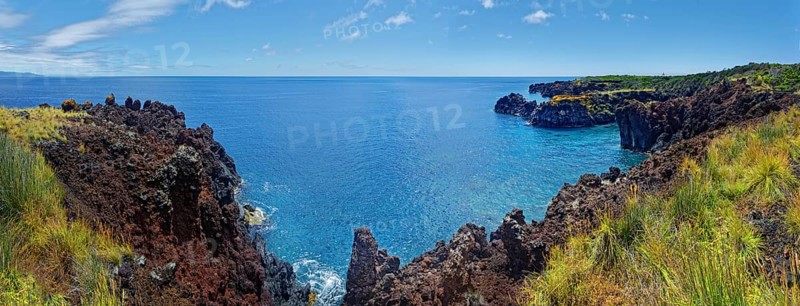 Panoramic view of a rugged coastal landscape with volcanic cliffs and sweeping sea views, lava rocks coastal hiking trail Ponta da Iiha, Manhenha, west coast, Pico, Azores