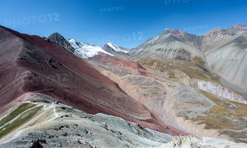 Mountain landscape of glacial moraines, mountains with red and yellow rocks, glaciated mountains in the background, Traveller's Pass below Pik Lenin, Trans Alay Mountains, Pamir Mountains, Osh Province, Kyrgyzstan, Asia