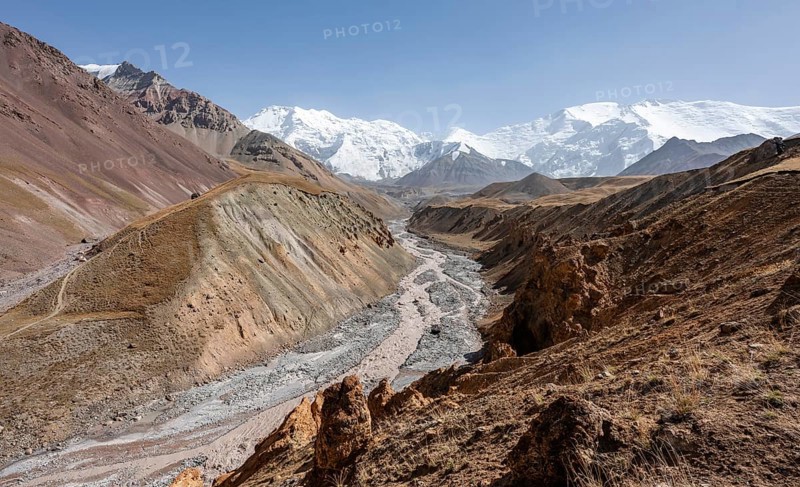 Achik Tash river, Achik Tash valley with rock formations, behind glaciated and snow-covered mountain peak Pik Lenin and Pik of the XIX Party Congress of the CPSU, Trans Alay Mountains, Pamir Mountains, Osh Province, Kyrgyzstan, Asia