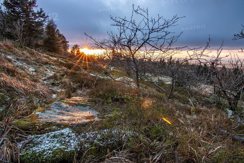Landscape on the Grosser Feldberg, Taunus volcanic region. A cloudy, sunny winter day, meadows, hills, snow and forests with a view of the winter sunset. Hesse, Germany, Europe