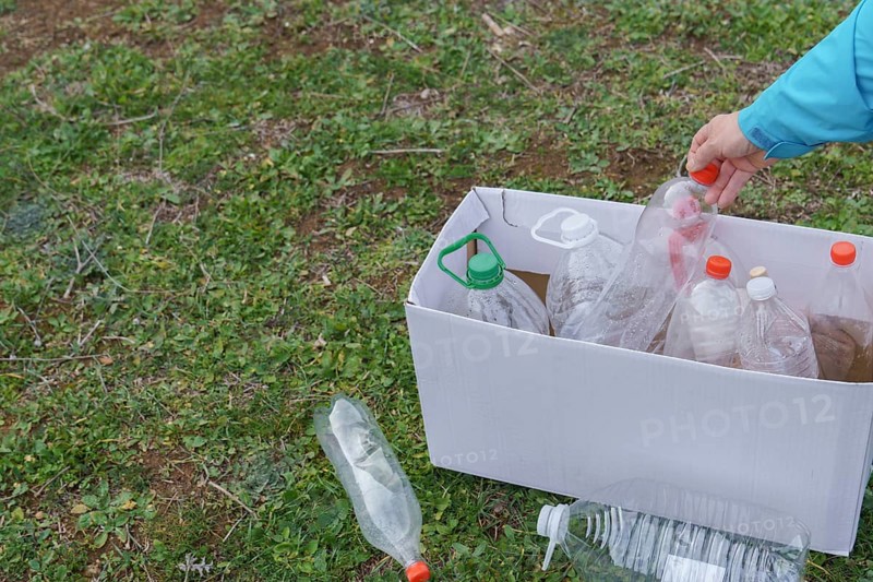 Woman collecting empty plastic bottles in the field to recycle, concept of ecology and respect for the environment