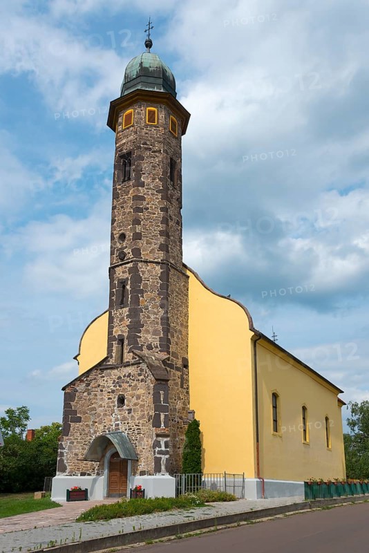 Stone church tower architecture under a cloudy sky next to a pavement, St. Nicholas Church, Gyoengyoessolymos, Gyoengyoes Matra, Heves, Northern Hungary, Hungary, Europe