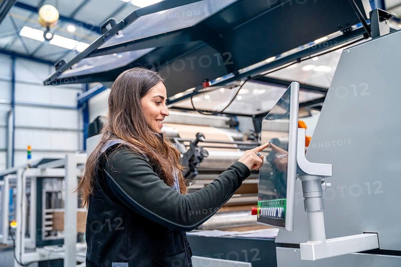 Female worker using a cnc machine to control an industrial crane