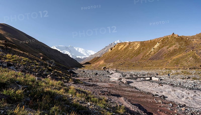 Bridge over the river Achik Tash, Achik Tash valley, behind glaciated and snow-covered mountain peak Pik Lenin, Trans Alay Mountains, Pamir Mountains, Osh Province, Kyrgyzstan, Asia