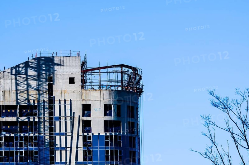 Yeoso, South Korea: December 25, 2017: Top of a building under construction with tree branches in foreground