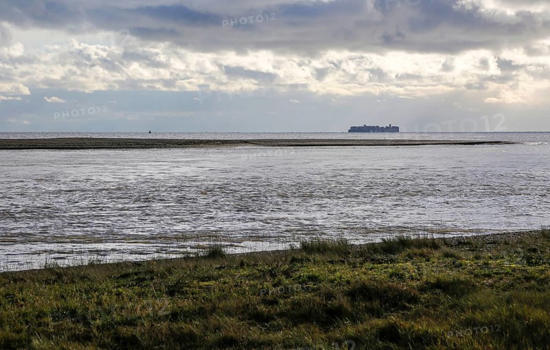 North Weir Point tip end of Orford Ness shingle spit, River Ore, Shingle Street, Suffolk, England, UK distant MSC container ship in North Sea