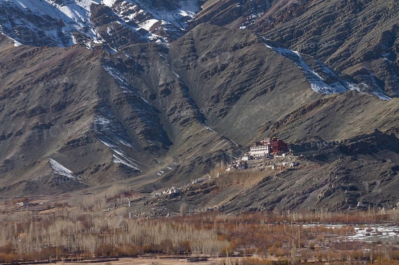 Matho Gompa, the Buddhist monastery of Central Ladakh, seen in winter, from the Thikse Monastery located on the opposite side of the Indus Valley. Mountains behind the monastery, with clearly visible strata, the rock layers, belong to the Zanskar Range of the Himalayas. Many inhabitants of Ladakh follow the Tibetan Buddhism, and this Indian region is often called Little Tibet. District Leh, Union Territory of Ladakh, India, Asia