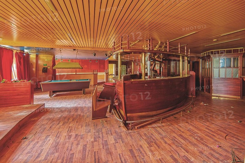An empty and run-down bar room with a pool table and red curtains, Bad am Park, Lost Place, Essen, North Rhine-Westphalia, Germany, Europe