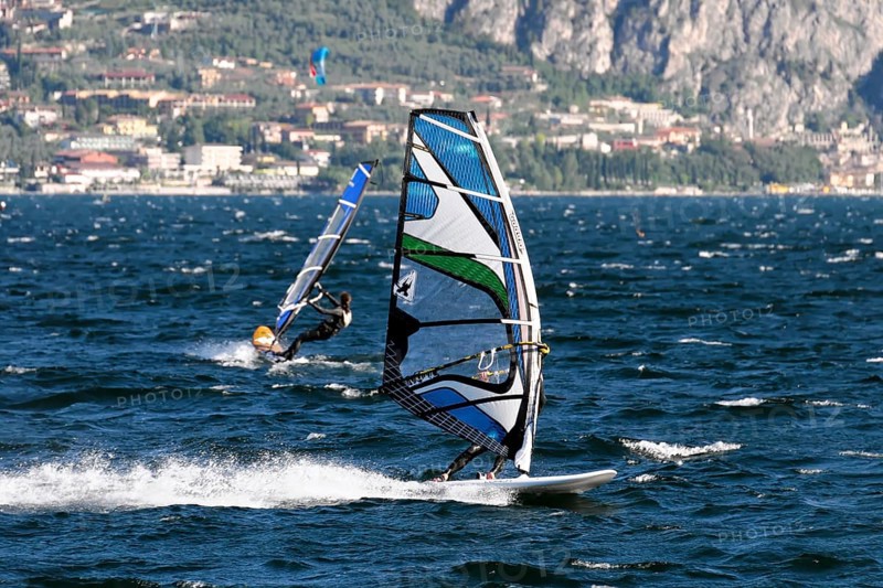 Windsurfers surfing in strong winds on Lake Garda near Malcesine, Veneto, Italy, Europe