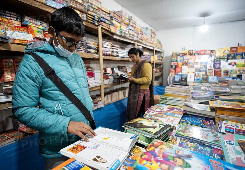 Book readers browsing books at a stall during Assam Book Fair, in Guwahati, Assam, India on 29 December 2023