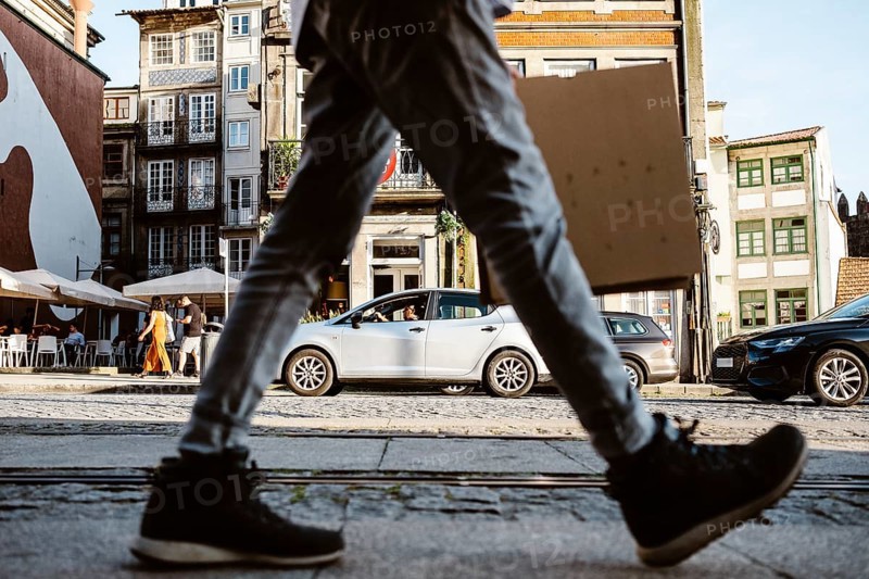 Street full of life, commuters, tourists, cars in a move in Porto, Portugal, Europe
