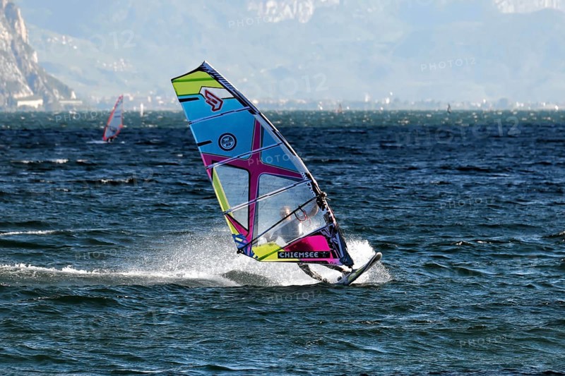Windsurfers surfing in strong winds on Lake Garda near Malcesine, Veneto, Italy, Europe