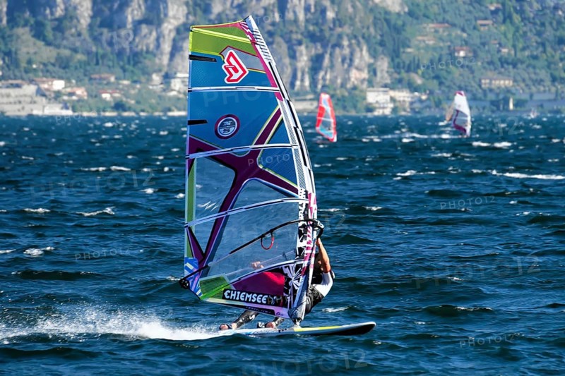 Windsurfers surfing in strong winds on Lake Garda near Malcesine, Veneto, Italy, Europe