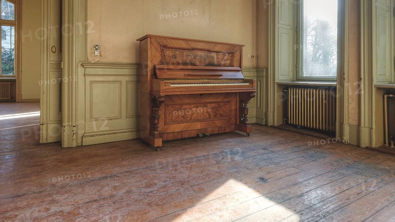 An old piano in a room with a wooden floor and large windows through which sunlight falls, Villa Woodstock, Lost Place, Wuppertal, North Rhine-Westphalia, Germany, Europe