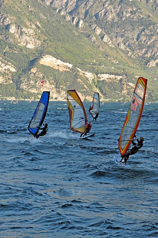 Windsurfers surfing in strong winds on Lake Garda near Malcesine, Veneto, Italy, Europe