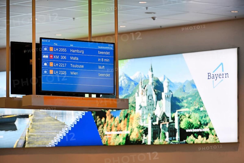 Arrival sign for Lufthansa and Star Alliance partners at the baggage carousel in Terminal 2 with advertising poster for Bavaria with Neuschwanstein Castle, Munich Airport, Upper Bavaria, Bavaria, Germany, Europe
