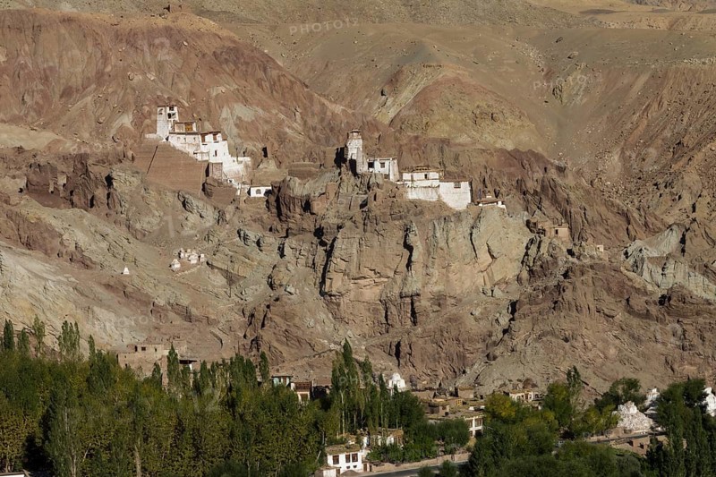 Basgo Gompa, the Buddhist monastery and fortress in Central Ladakh, with the village below it and rugged mountain landscape around. Photographed on a sunny day in September, the late summer. Many inhabitants of this Indian region, which is often called Little Tibet, follow the Tibetan Buddhism. Leh District, Union Territory of Ladakh, India, Asia
