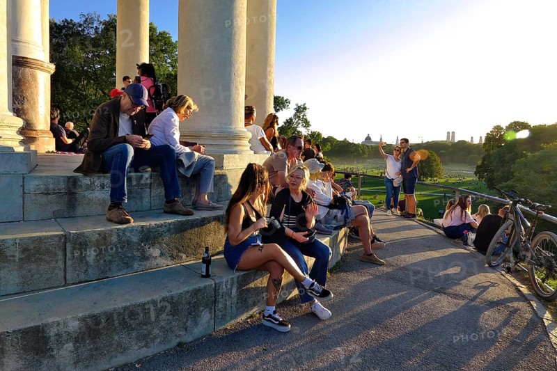 People enjoying the autumn sun at the Monopteros in the English Garden, with a view of the Munich skyline, Munich, Bavaria, Germany, Europe